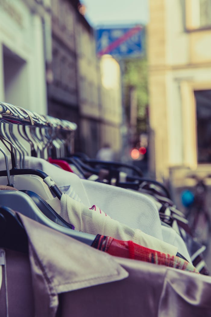 Clothing items hanging on a rack outdoors, featuring a warm and vintage tone.