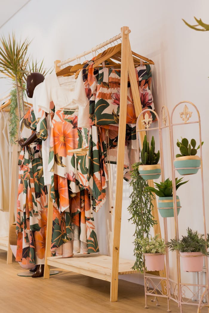 Floral print clothing elegantly displayed in a modern boutique with lush green plants for decoration.